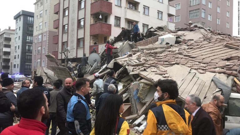 倒壊した建物で作業を行う警官や救助隊＝６日/Anadolu Agency/Anadolu/Getty Images