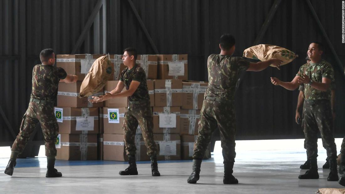 ベネズエラに近いブラジル・ボアビスタで粉ミルクの袋を受け渡すブラジル軍兵士/NELSON ALMEIDA/AFP/Getty Images