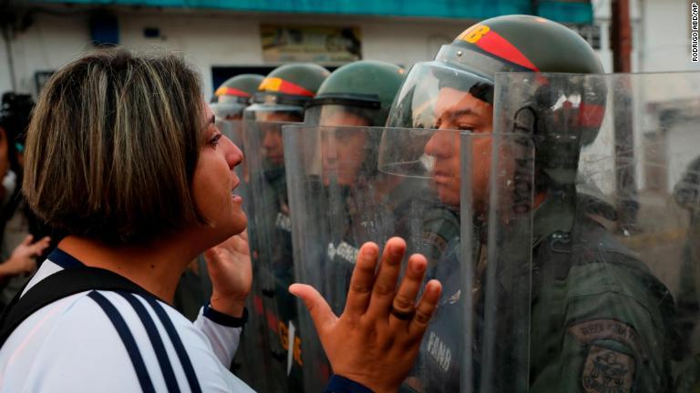 治安部隊員と対峙する女性＝２３日、ベネズエラ・ウレニャ/Rodrigo Abd/AP