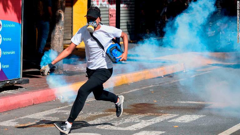 催涙ガスから逃げるデモ参加者＝１月２３日/Federico Parra/AFP/Getty Images