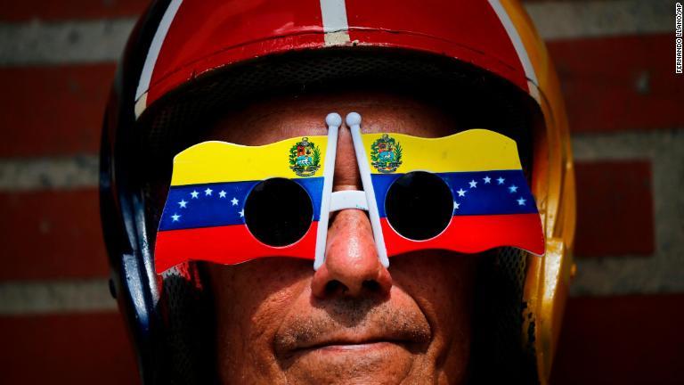 ベネズエラ国旗をあしらった眼鏡を身に着けた反政府デモの参加者＝２日/Fernando Llano/AP