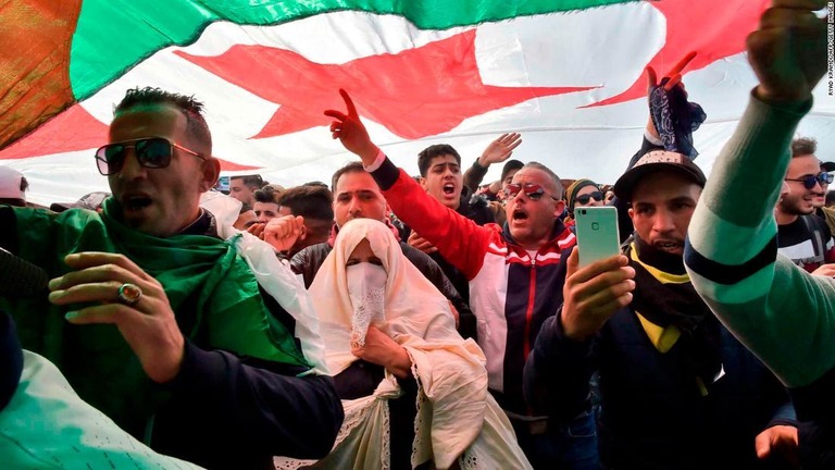 デモで国旗を掲げてスローガンを連呼する人々＝１日/RYAD KRAMDI/AFP/Getty Images