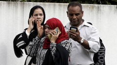 モスク前で携帯電話で話す人々