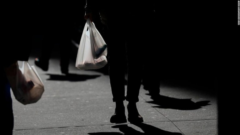 ニューヨーク市民がお昼休みにポロ袋を手にさげて歩く様子＝１月１５日/Drew Angerer/Getty Images