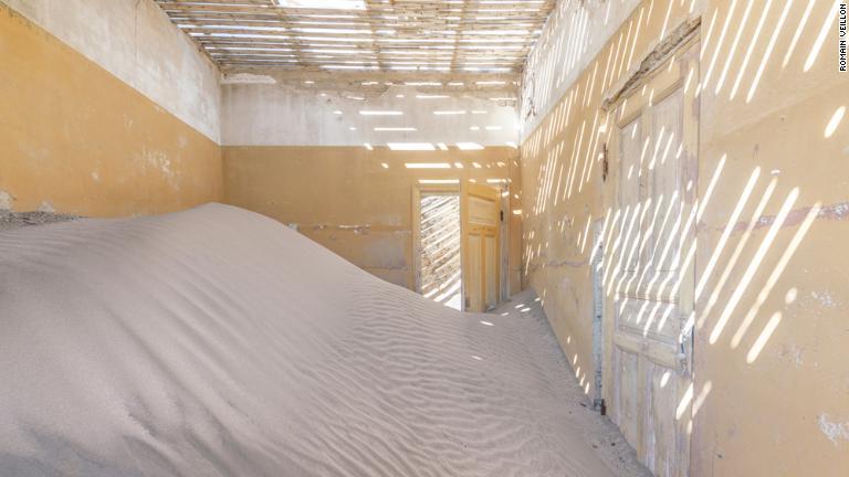 一部が砂にのみ込まれているかのような建物/Romain Veillon