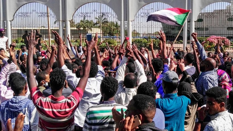 スーダン首都にある軍司令部の前に大挙して押し寄せ、政府への抗議の声を上げる人々/AFP/Getty Images
