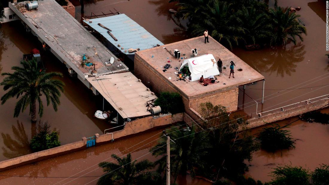 屋根に避難する住民ら＝５日、フーゼスタン州/AZIZ BABANEJAD/AFP/AFP/Getty Images