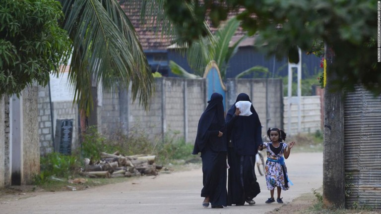 スリランカ東部カッタンクディーで少女と歩くブルカを着用した女性/LAKRUWAN WANNIARACHCHI/AFP/Getty Images
