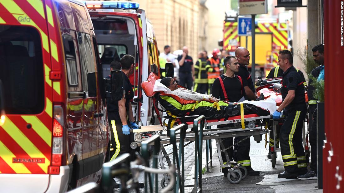 負傷者を救急車に乗せる救急隊員ら=24日/Philippe Desmazes/AFP/Getty Images