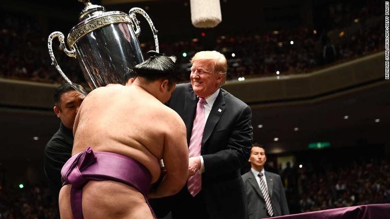 大相撲夏場所で優勝した朝乃山に大統領杯を手渡すトランプ大統領＝２６日/Brendan Smialowski/AFP/Getty Images