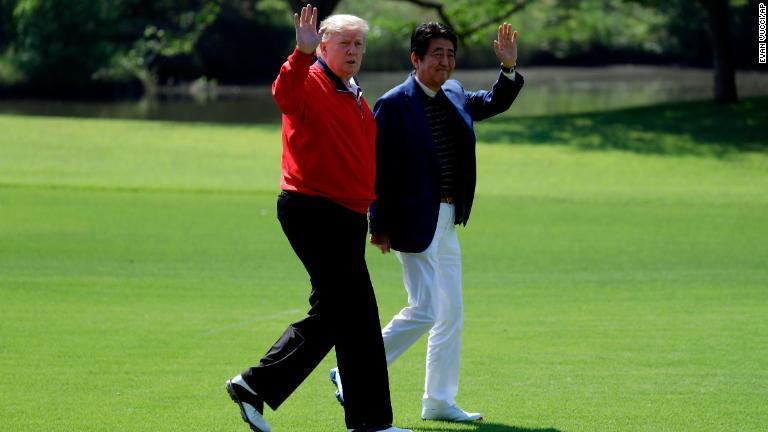 ゴルフ開始前に一緒に歩くトランプ氏と安倍氏/Evan Vucci/AP