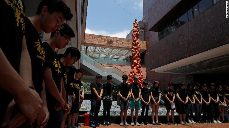 黙とうをささげる香港大学の学生/Kin Cheung/AP