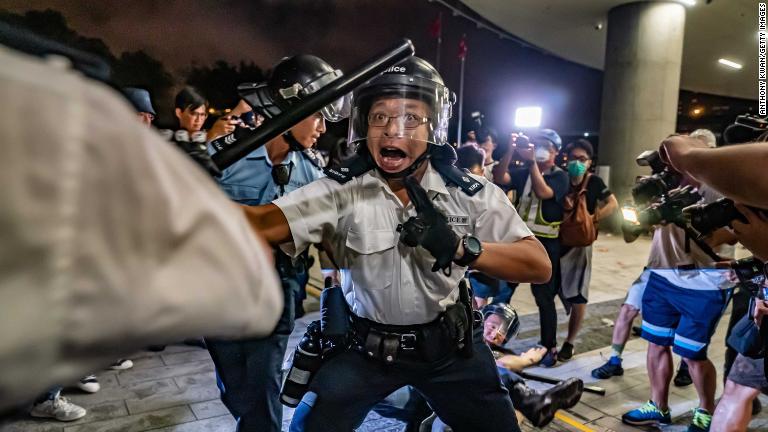 デモ参加者に突進する警官＝１０日/Anthony Kwan/Getty Images