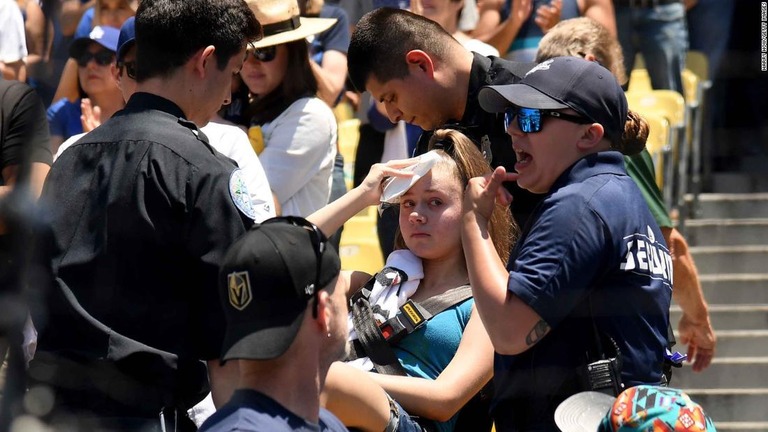 ドジャースタジアムで試合を観戦中、頭部にファウルボールが直撃した女性/Harry How/Getty Images