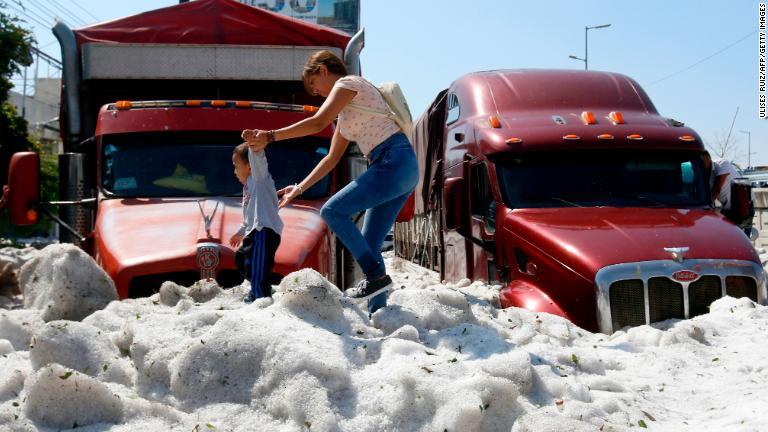 氷の上を歩く女性と子ども/Ulises Ruiz/AFP/Getty Images