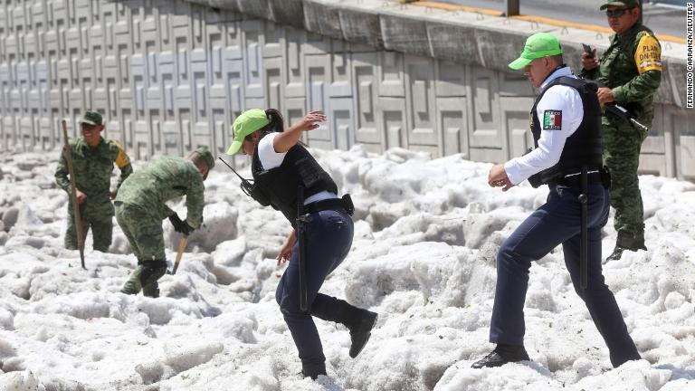 治安部隊と兵士が氷の除去を試みる様子/Fernando Carranza/Reuters