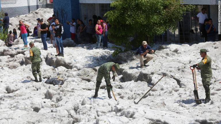 氷の除去を試みる兵士/Fernando Carranza/Reuters