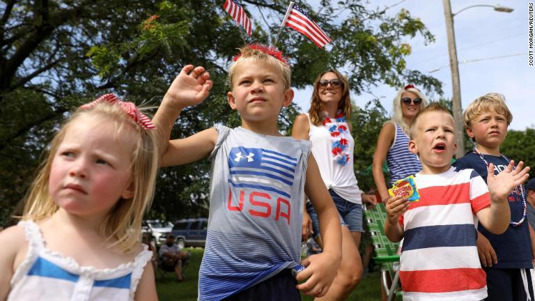 アイオワ州ノーウォークで、パレード参加者に沿道から手を振る子どもたち/Scott Morgan/Reuters