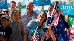 パレードに参加して笑顔を見せる民主党大統領候補者のエイミー・クロブチャー氏（中央）＝マサチューセッツ州アマースト