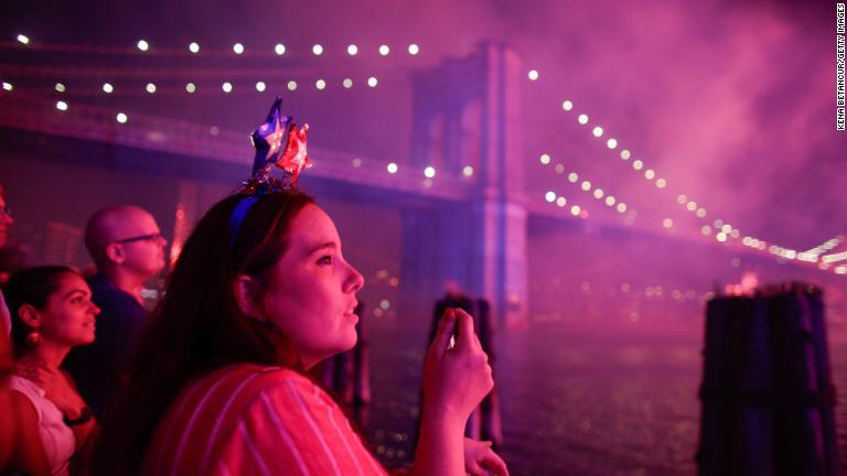 ニューヨーク、ブルックリン橋の近くで花火を見る女性/Kena Betancur/Getty Images