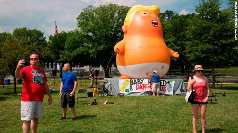 「トランプ・ベイビー」の巨大風船の前で写真を撮る男性＝ワシントン/Alastair Pike/AFP/Getty Images