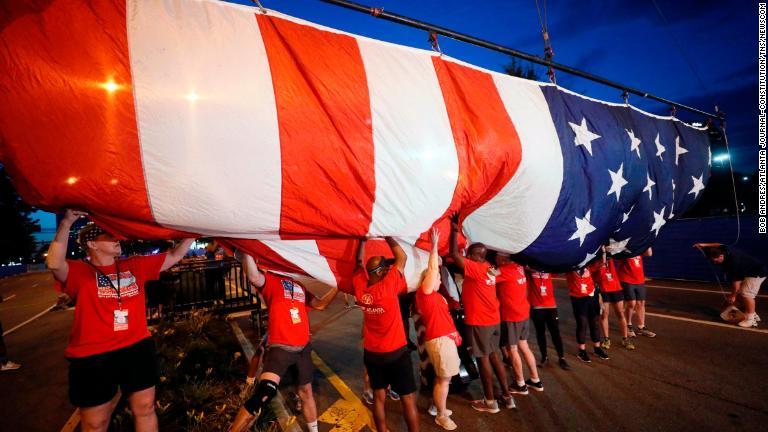 ジョージア州アトランタで毎年独立記念日に開かれる１０キロ走大会の運営に携わるボランティア。今年は５０回目を記念して巨大な星条旗が用意された/Bob Andres/Atlanta Journal-Constitution/TNS/Newscom