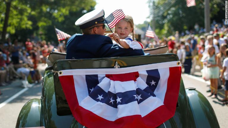 パレードの車上から星条旗を振る女の子＝マサチューセッツ州ケープコッド/Mike Segar/Reuters