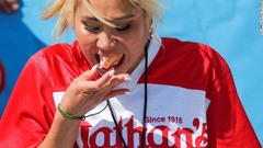 毎年恒例のホットドッグの早食い選手権に参加する女性＝ニューヨーク