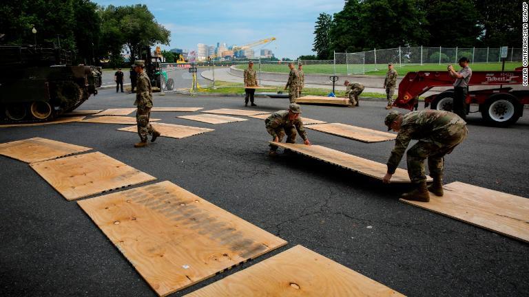 戦車の展示のため保護用のベニヤ板を道路に敷き詰める軍関係者ら＝ワシントン/Oliver Contreras/SIPA USA/AP