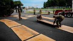 戦車の展示のため保護用のベニヤ板を道路に敷き詰める軍関係者ら＝ワシントン