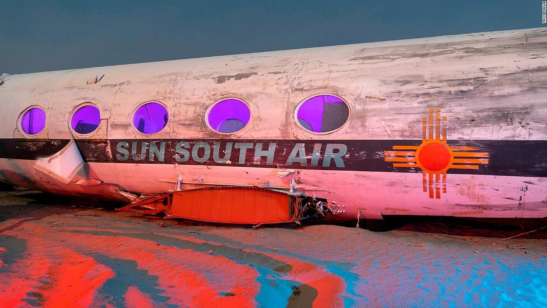古い映画の舞台装置として使われた機体が赤と紫の光に照らされている/Troy Paiva