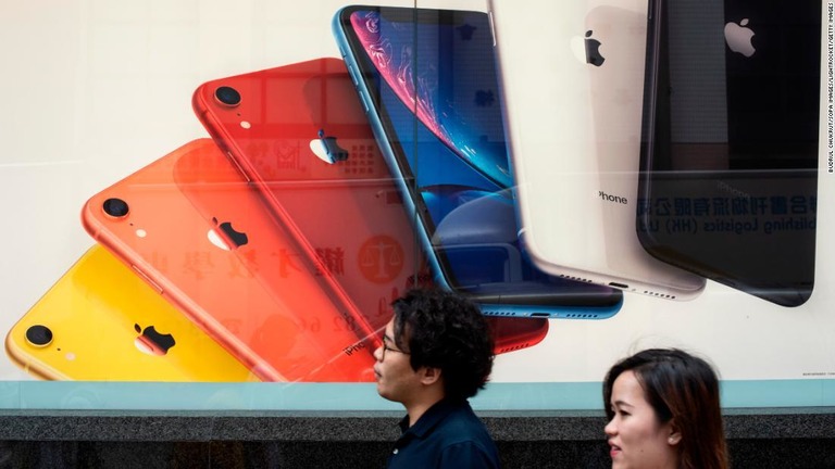 アップルのスマホ「ｉＰｈｏｎｅ」の広告の前を通り過ぎる人々＝６月、香港/Budrul Chukrut/SOPA Images/LightRocket/Getty Images