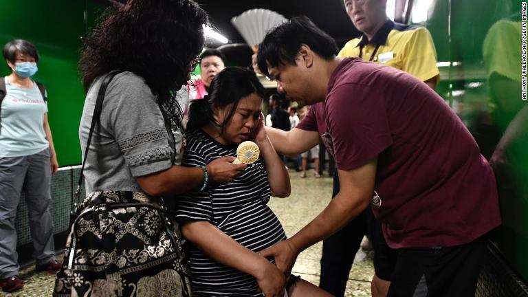 妊婦の様子を見る男性＝５日/Anthony Wallace/AFP/Getty Images