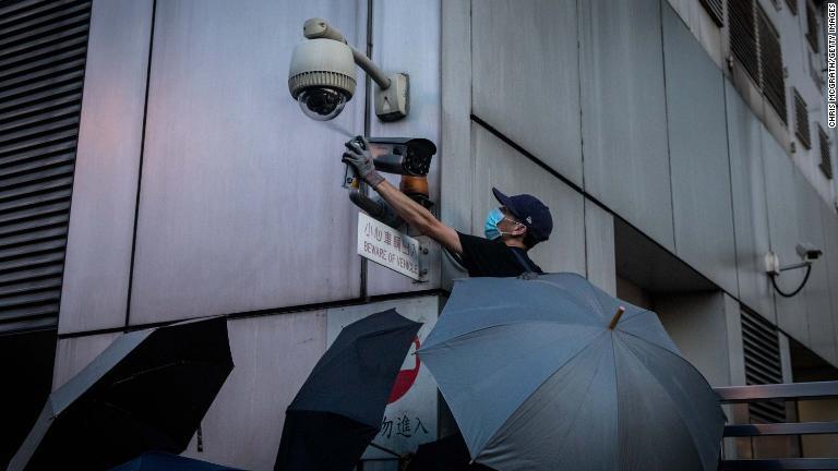 監視カメラをふさぐデモ参加者/Chris McGrath/Getty Images