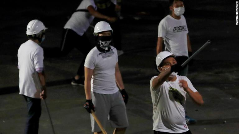 白いシャツを着て顔をマスクで隠した人物らが元朗駅でデモ隊を襲撃した/Tyrone Siu/Reuters
