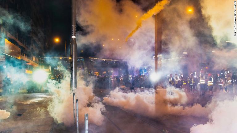 行進するデモ隊に催涙ガスを打つ警官＝７月２１日/Billy H.C. Kwok/Getty Images
