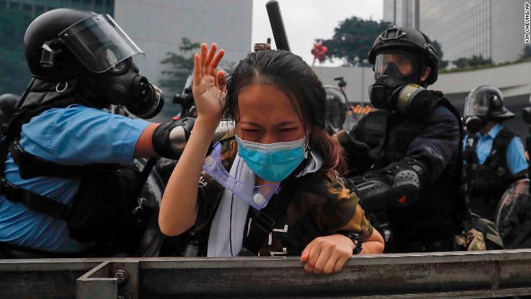 デモ参加者を拘束する警官＝６月１２日/Kin Cheung/AP