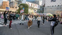 リンボーダンスをしながら横断歩道を渡る人たち