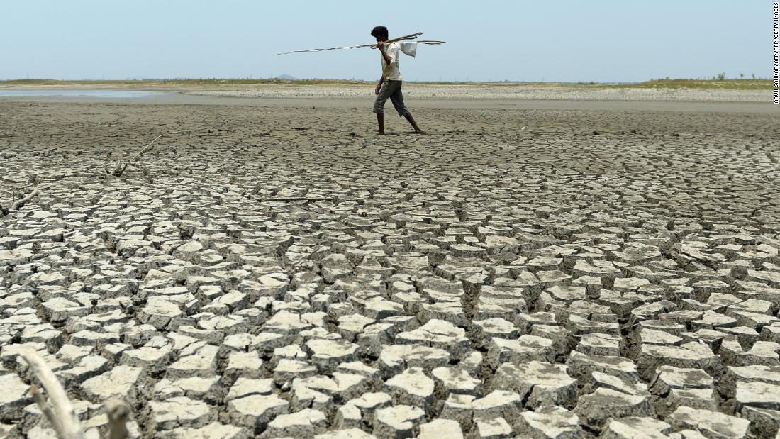 枯れた貯水池を歩く男性/ARUN SANKAR/AFP/AFP/Getty Images