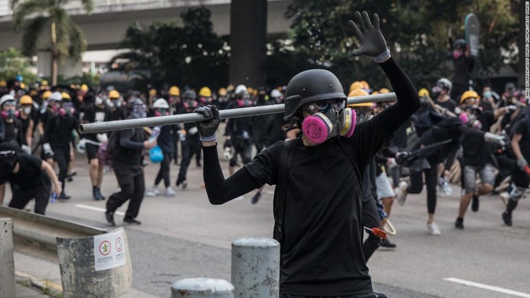 鉄の棒を投げようとするデモ参加者/Chris McGrath/Getty Images AsiaPac/Getty Images