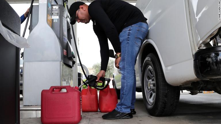 ガソリンを容器に入れる男性＝２９日、フロリダ州ハイアリア/Lynne Sladky/AP