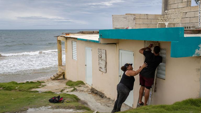 プエルトリコ・ヤブコアで自宅の窓を木で覆う男性。結局、プエルトリコはハリケーンの強風の直撃を免れた＝２８日/Joe Raedle/Getty Images