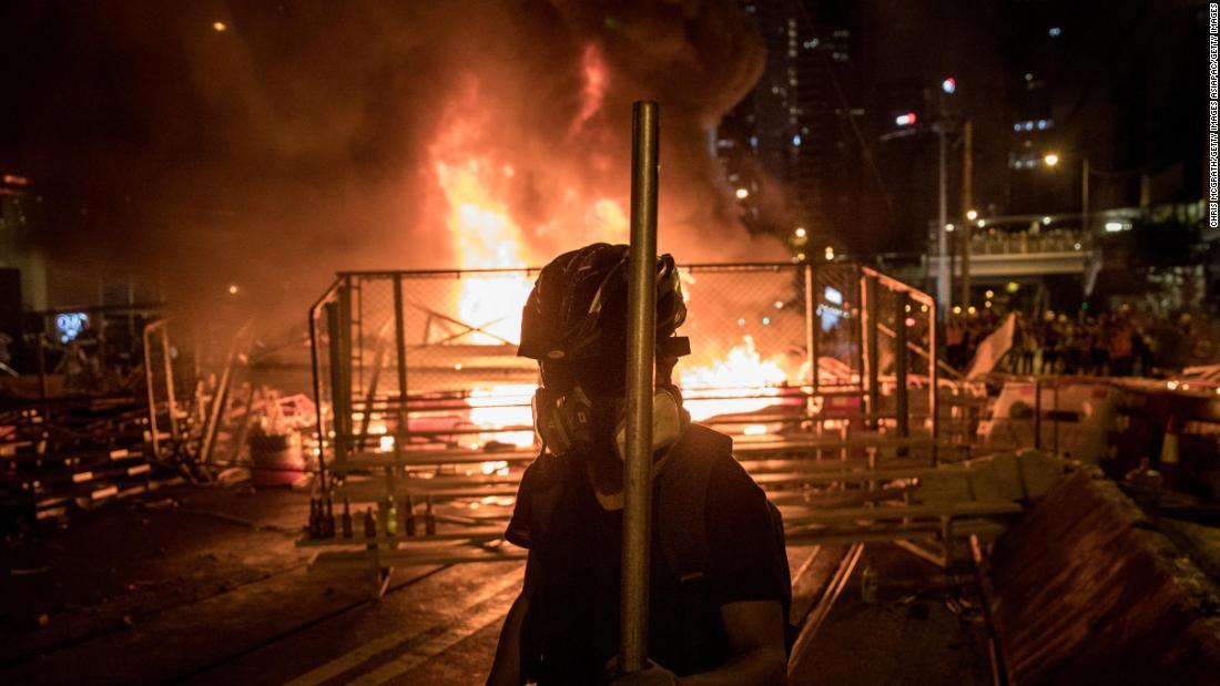 火がついたバリケートの周辺を歩くデモ参加者＝３１日/Chris McGrath/Getty Images AsiaPac/Getty Images