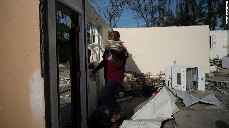 バハマ・パインベイで息子の自宅から食器を回収する住民/Ramon Espinosa/AP