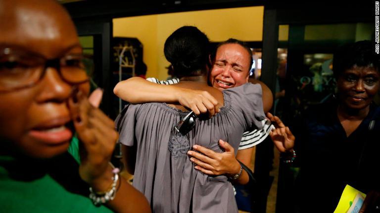 救出されバハマ首都ナッソーに到着した女性が教会の仲間と抱き合い涙を見せた/Jose Jimenez/Getty Images