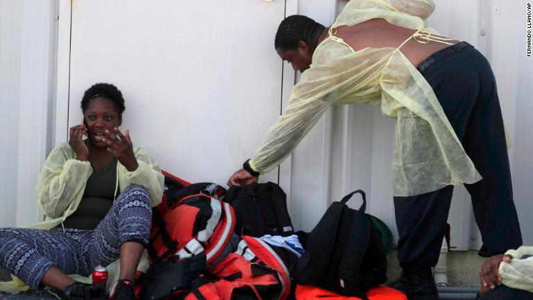 避難したバハマの女性が携帯電話で会話/Fernando Llano/AP