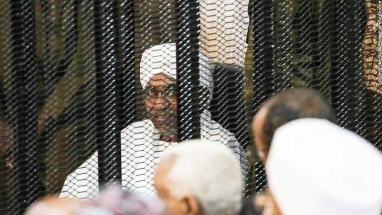 ケージの中で審理を受けるスーダン前大統領のバシル被告/Anadolu Agency/Anadolu/Anadolu Agency via Getty Images