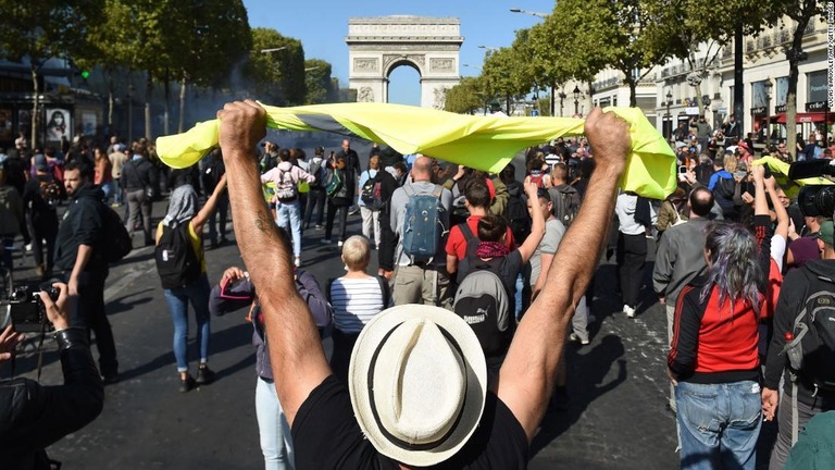 凱旋門を前に黄色のベストを持って抗議を行う人々/LUCAS BARIOULET/AFP/Getty Images