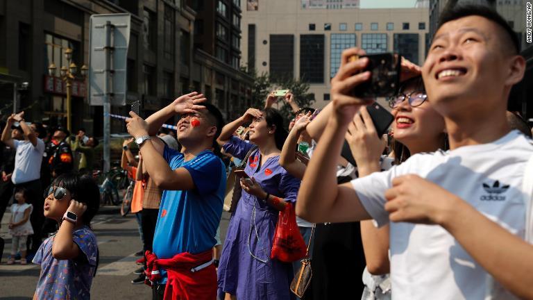 航空機の編隊飛行をながめる人たち/Andy Wong/AP