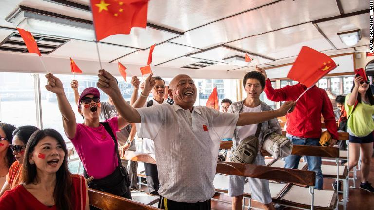 中国国旗を振る中国政府支持派の人々＝香港/Laurel Chor/Getty Images